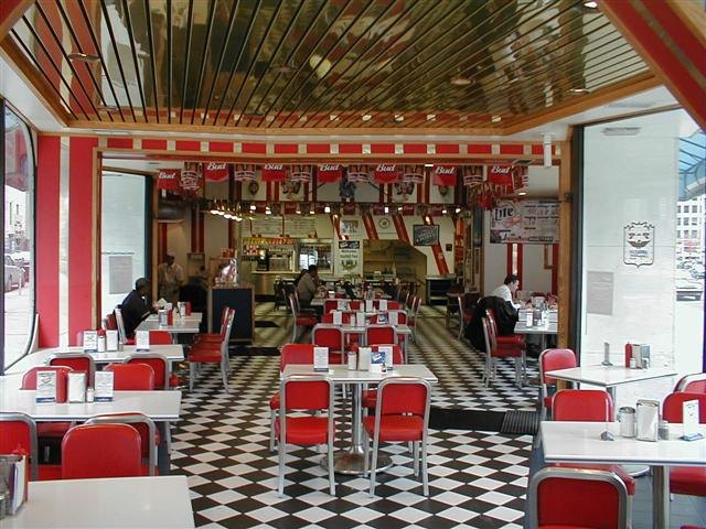 The dining room today: red vinyl chairs, chrome tables and a black-and-white checkerboard floor